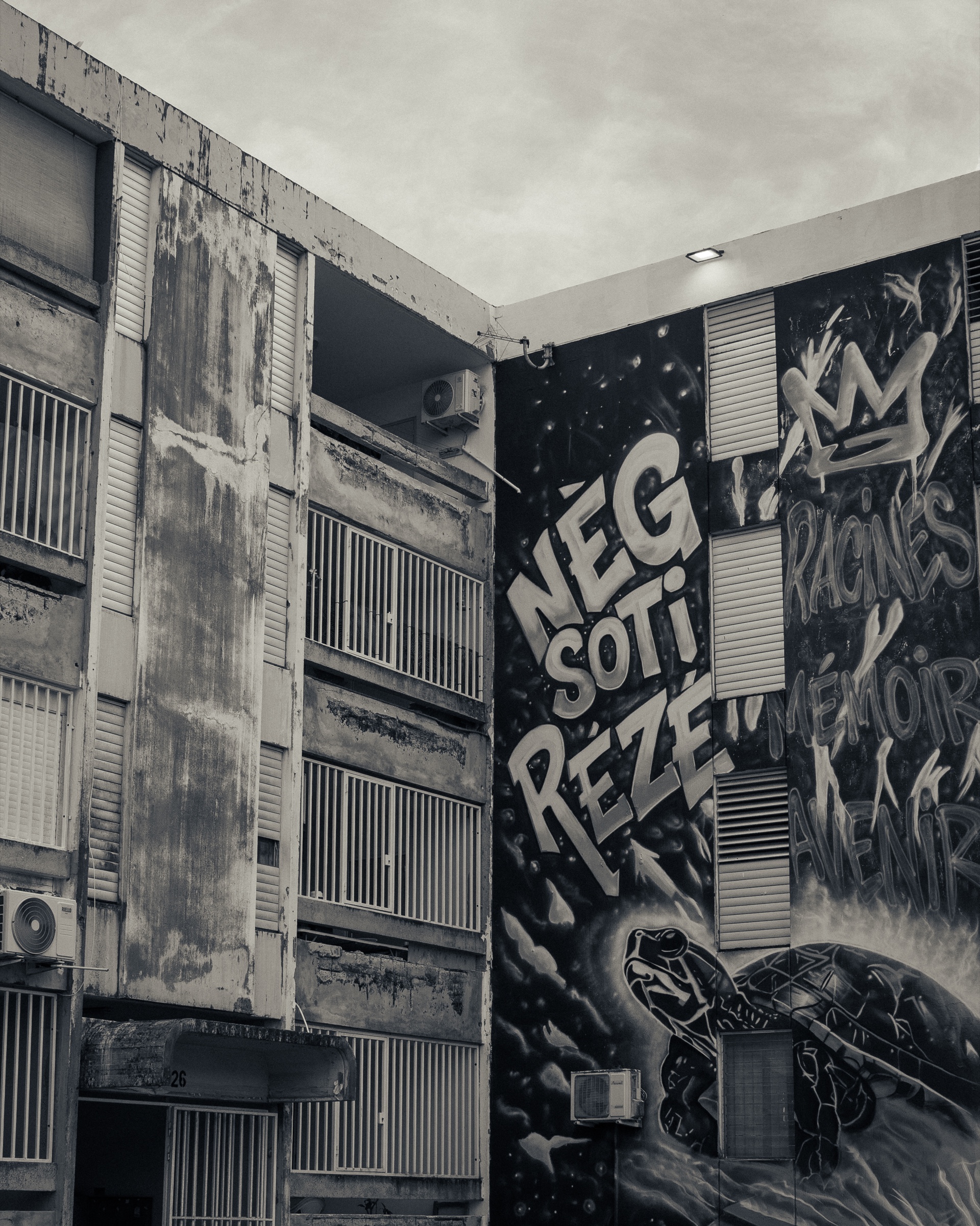 Fresque urbaine en noir et blanc portant le message Neg soti rézé