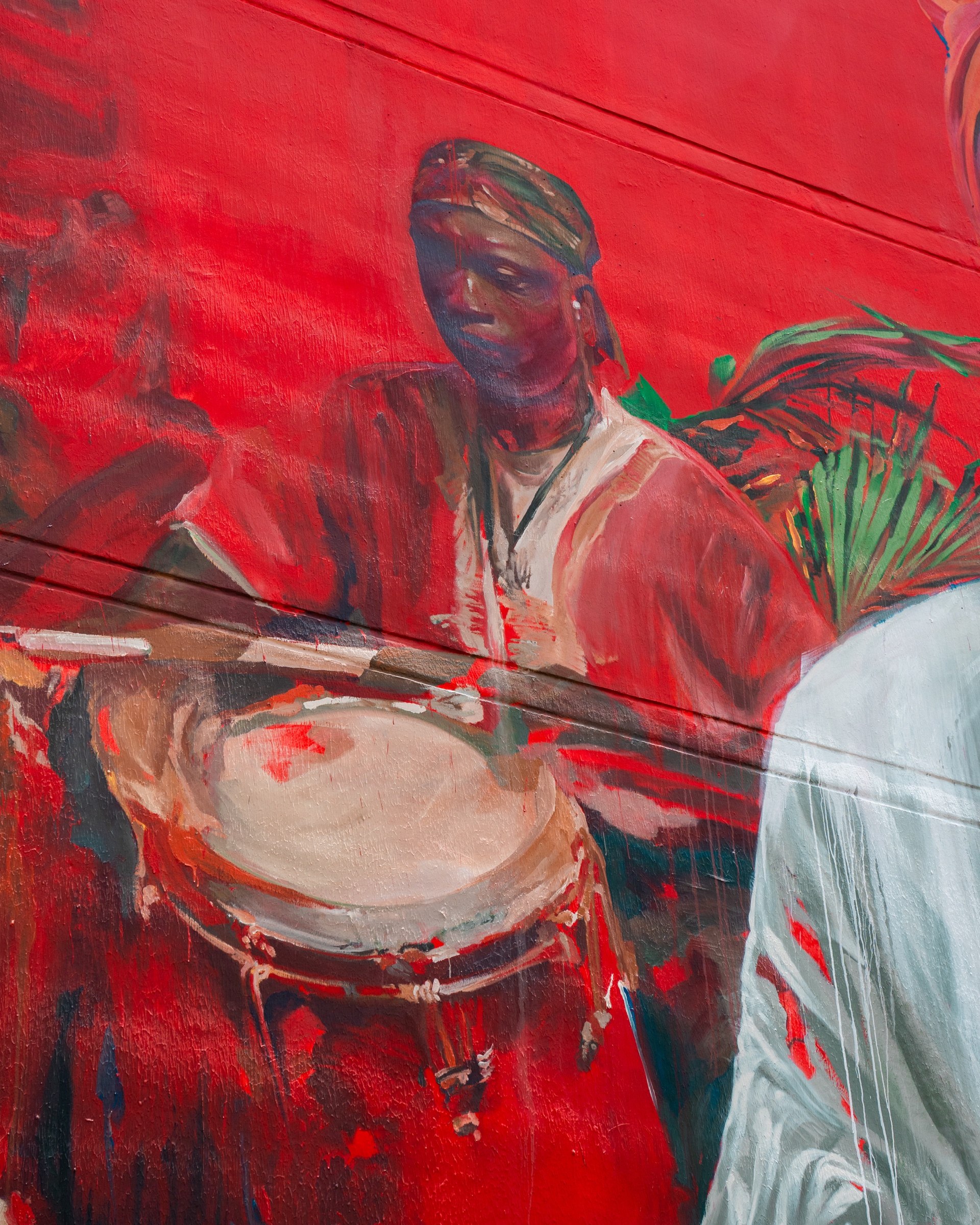 Détail d’un joueur de tambour peint sur une fresque rouge